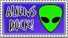 green alien face stamp that reads aliens rock